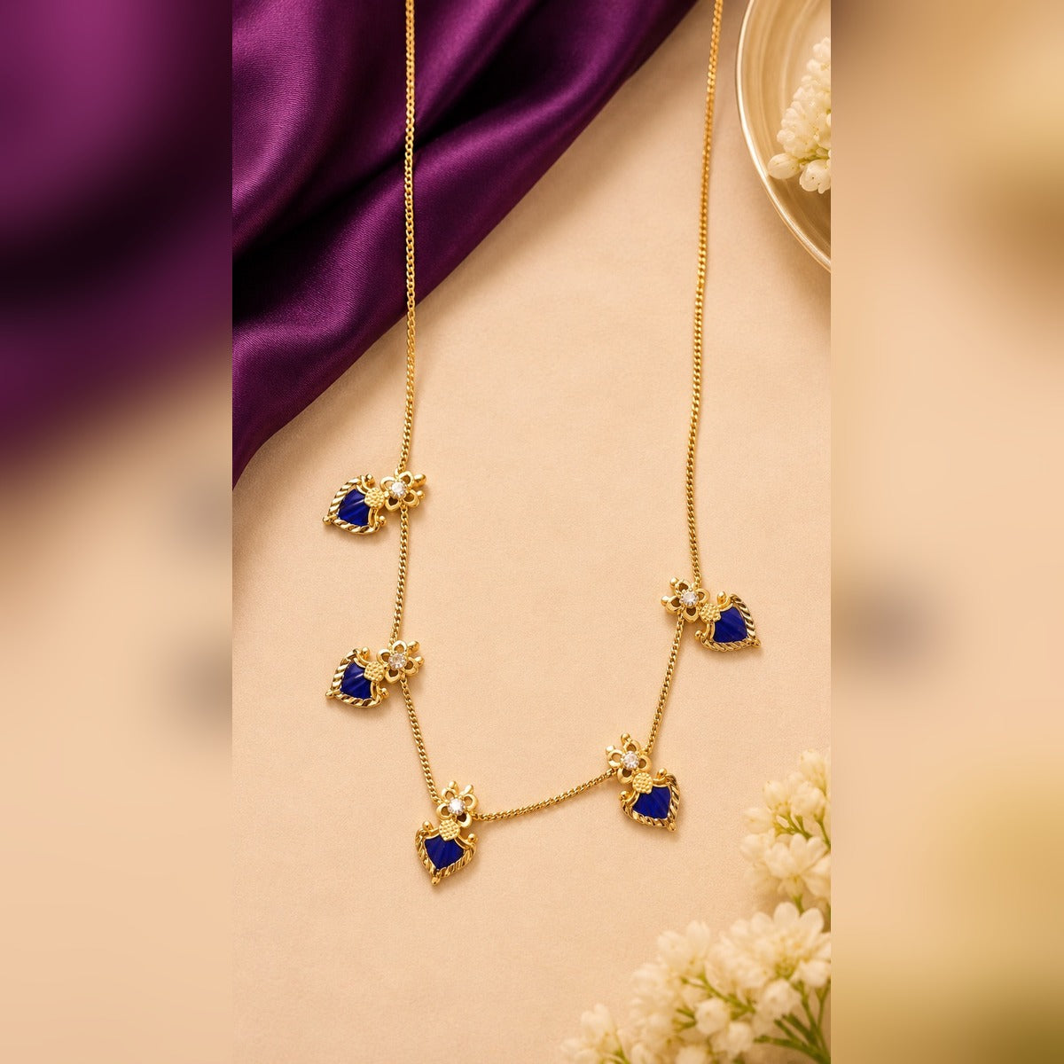 Gold chain necklace with dark-blue enamel heart charms and crystal flower connectors