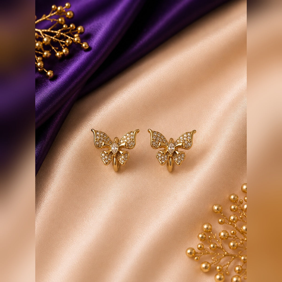 Gold pavé butterfly stud earrings with a marquise centre stone