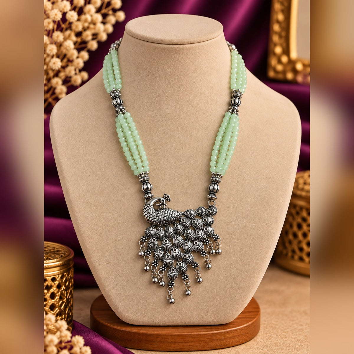 Oxidized silver peacock pendant necklace with multi-strand mint beads and ball drops, on a display bust