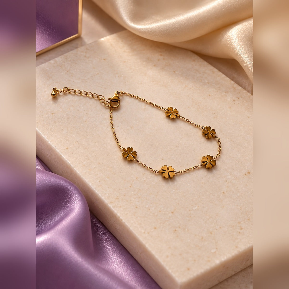 Delicate gold chain bracelet with five polished clover charms