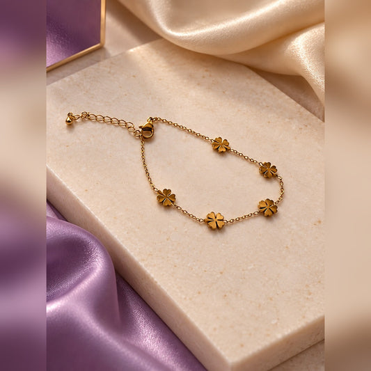 Delicate gold chain bracelet with five polished clover charms