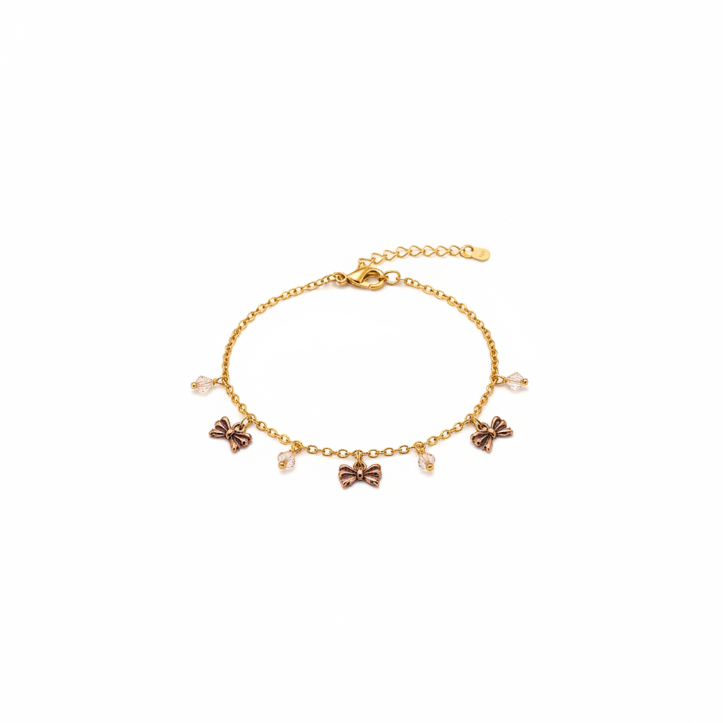 Gold bow charm bracelet with crystal drops on white background studio photography