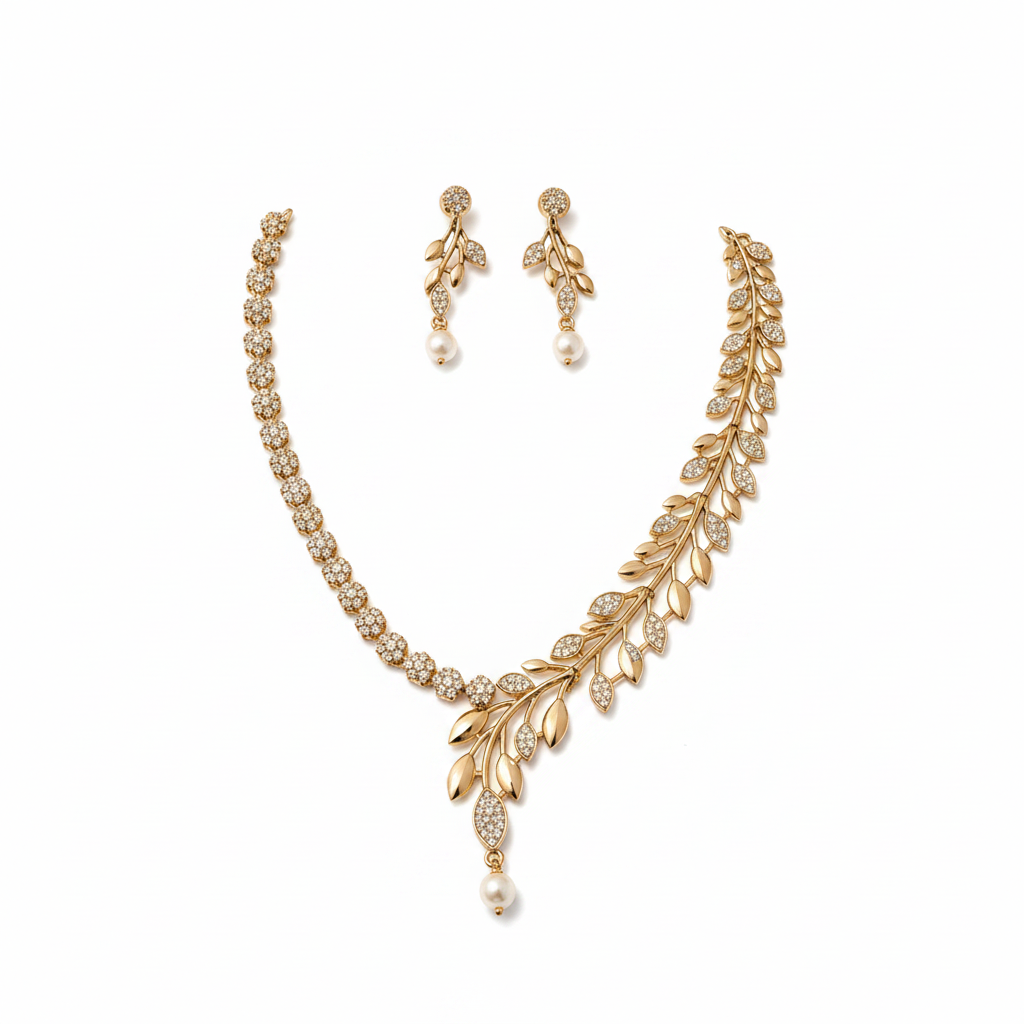 Gold asymmetric wheat leaf vine crystal pave pearl drop necklace and earring set on pure white background studio photography
