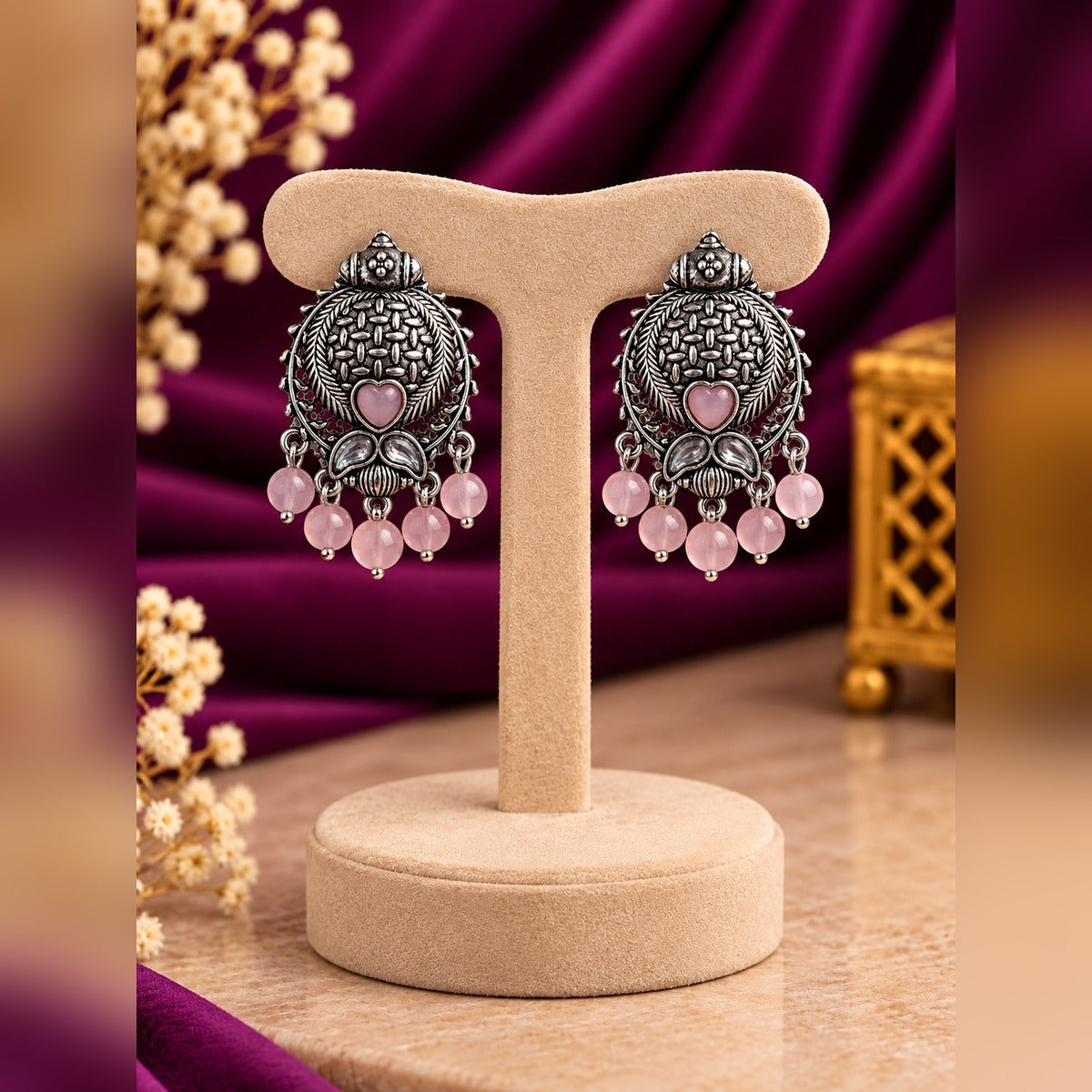 Oxidized silver pink heart drop earrings on a stand