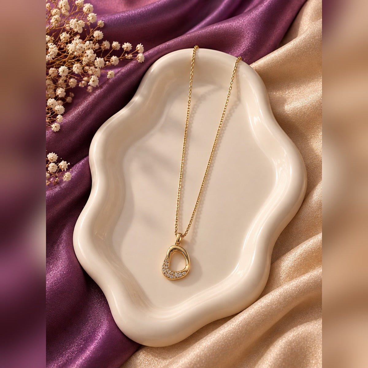 Gold necklace with open oval pendant lined with crystals